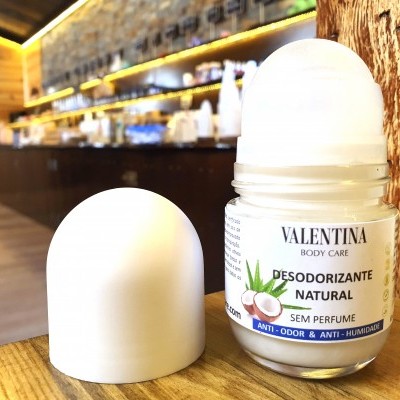 Desodorizante natural Valentina Body Care em stick com tampa branca sobre madeira