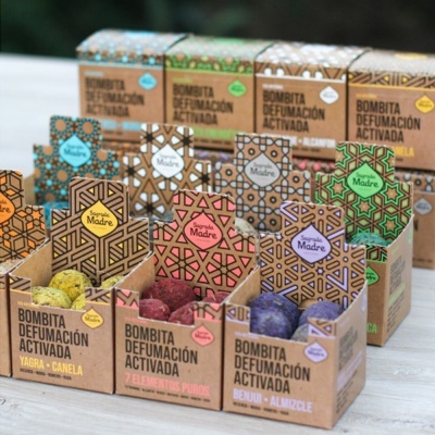 Caixas coloridas de Bombita Defumación Activada com padrões geométricos e bolas de defumação visíveis dentro.