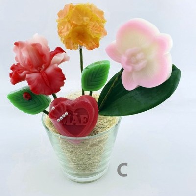 Arranjo artificial de flores coloridas em vaso de vidro com coração vermelho com texto 'PAF'