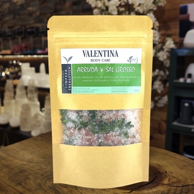 Pacote de arruda e sal grosso em embalagem kraft com etiqueta verde e branca, em loja