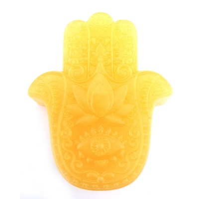 Sabonete amarelo em forma de mão de Hamsá com detalhes em relevo