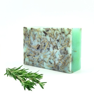 Sabonete artesanal verde com ervas e ramo de alecrim fresco