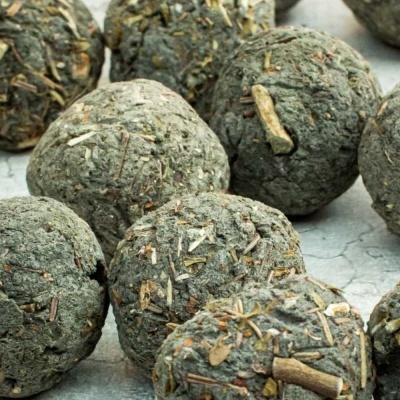 Bolas esféricas de matéria vegetal com ervas secas visíveis