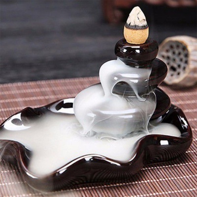 Incensário cerâmico preto e branco em cascata com cone de incenso aceso