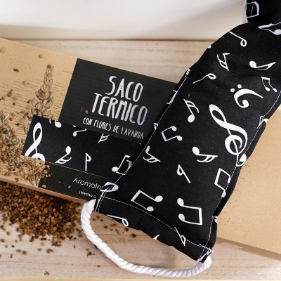 Saco térmico preto com notas musicais brancas e embalagem de cartão com texto em espanhol
