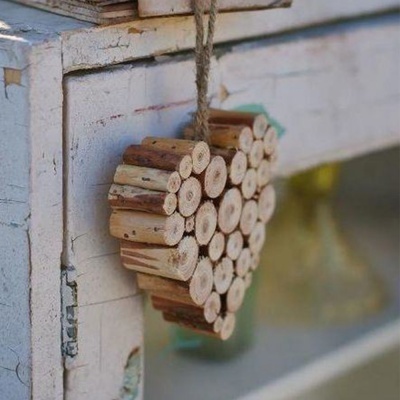 Ornamento de coração em madeira pendurado em móvel branco envelhecido