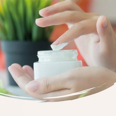 Mãos femininas seguram um frasco branco de creme cosmetic.