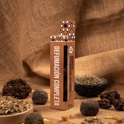 Embalagem castanha de defumação com varetas, sobre tecido e ervas