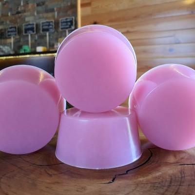 Sabonetes redondos rosa empilhados sobre mesa de madeira