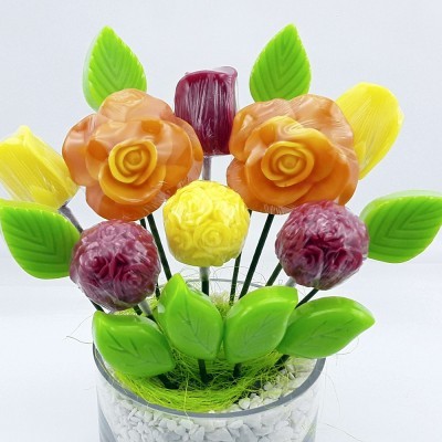 Arranjo de flores artificiais coloridas num vaso de vidro com pedras brancas