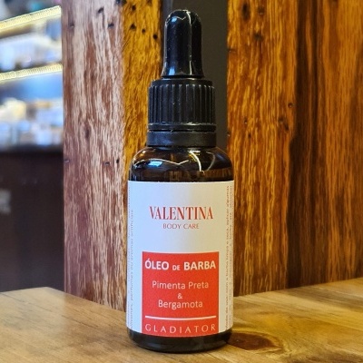 Frasco de óleo de barba VALENTINA BODY CARE com conta-gotas sobre mesa de madeira