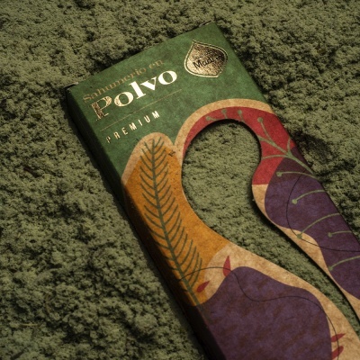 Embalagem colorida com texto 'Santuario en Polvo PREMIUM' sobre pó verde