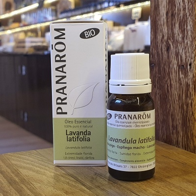 Frasco de óleo essencial Pranarôm Lavanda latifolia ao lado da embalagem sobre uma mesa de madeira