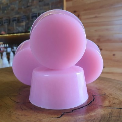 Barras de sabonete rosa empilhadas sobre mesa de madeira