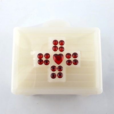 caixa branca de plástico com cruz vermelha em pedras no topo