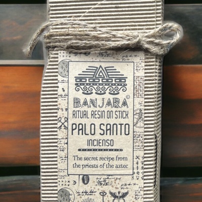 Embalagem de papel canelado bege com rótulo branco e texto azul amarrada com cordão de juta sobre fundo de madeira.