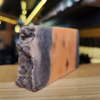 Bloco de sabão artesanal colorido sobre madeira clara