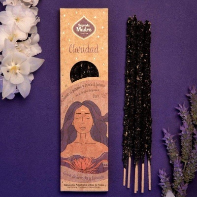 Incenso Sagrado Madre Claridad com embalagem laranja, três varetas de incenso pretas e flores ao lado