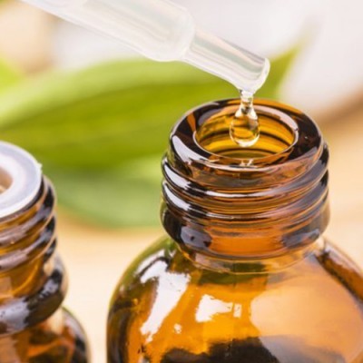 frascos de vidro âmbar com conta-gotas e folhas verdes ao fundo