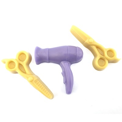 Brinquedos de tesouras amarelas e secador de cabelo roxo em fundo branco