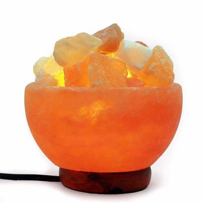 Lâmpada de sal luminosa laranja em tigela com base de madeira e cabo preto