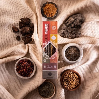 Pacote de incenso SIE7E CHAKRAS e potes com ervas secas sobre tecido bege