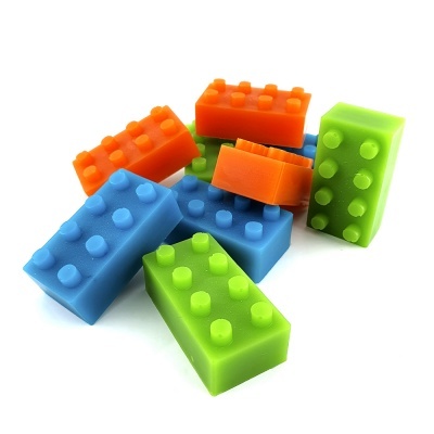 Blocos de construção coloridos em azul, verde e laranja com pinos salientes