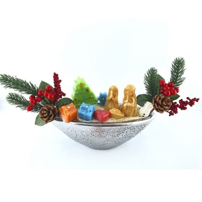 Centro de mesa natalício com base prateada e decorações como pinhas, bagas vermelhas, e árvore de Natal verde