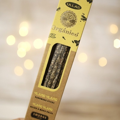 Caixa amarela com varetas e texto impresso