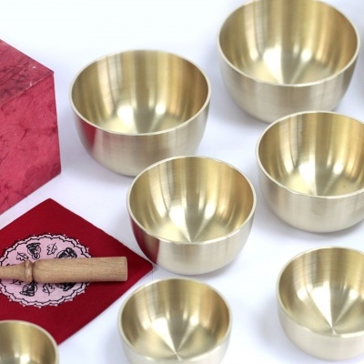 Conjunto de tigelas metálicas douradas com martelo de madeira e caixa vermelha