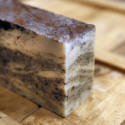 Sabonete artesanal retangular creme e castanho em superfície de madeira