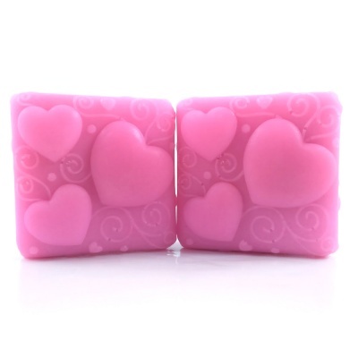 Sabonetes cor-de-rosa quadrados com corações em relevo e padrões de espirais