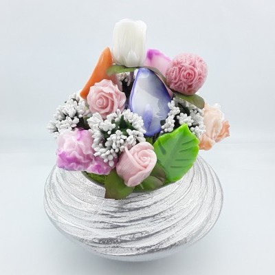 Arranjo decorativo com flores artificiais coloridas numa base prateada redonda