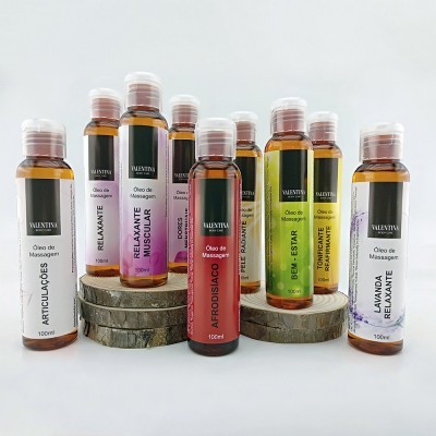 Frascos de óleo de massagem da Valentiva com rótulos coloridos e textos em português organizados sobre troncos de madeira