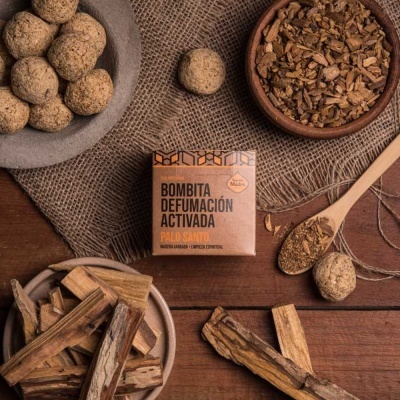 Caixa de Bombita Defumación Activada Palo Santo com pellets e lascas de madeira em fundo rústico