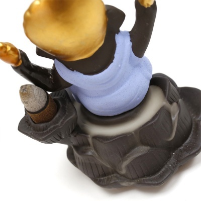 Figura decorativa em cerâmica com saia preta e colete azul, suporte com cone de incenso