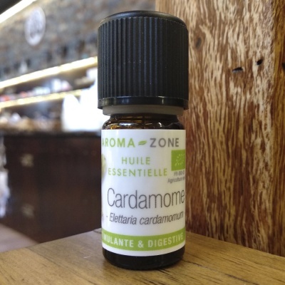 Frasco pequeno de óleo essencial de cardamomo com rótulo branco e verde