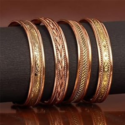 Pulseiras metálicas em tons cobre e dourado com padrões entalhados