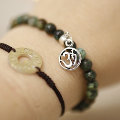 Braceletes com contas verdes e pendente prateado com símbolo Ôm