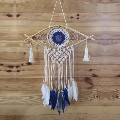 Sonho mexicano com corda branca, penas brancas e azuis, e aro de madeira pendurado em parede de madeira clara