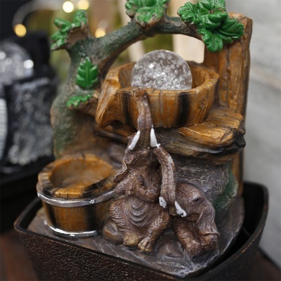 Fonte decorativa interior com elefantes, bola de cristal, folhas verdes e base preta
