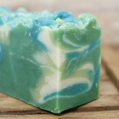 Sabonete marmoreado verde, azul e branco sobre madeira