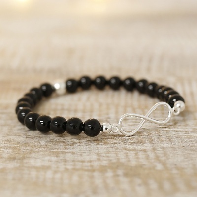 Pulseira com contas pretas e fecho infinito em metal prateado
