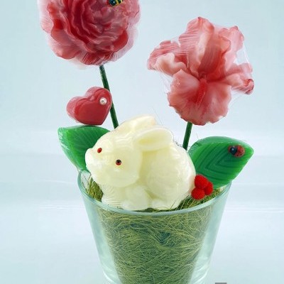 Vaso de vidro com flores vermelhas e rosa, coelho branco, coração vermelho e folhas verdes