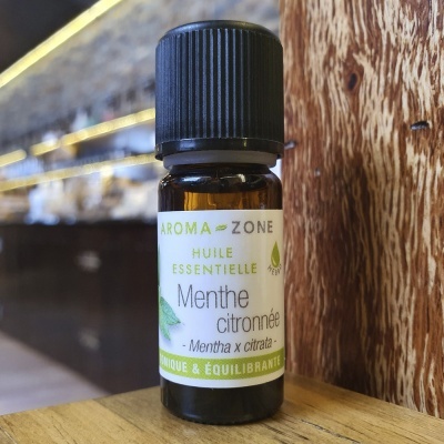 Frasco pequeno de óleo essencial de Mentha citronnée da Aroma Zone sobre superfície de madeira