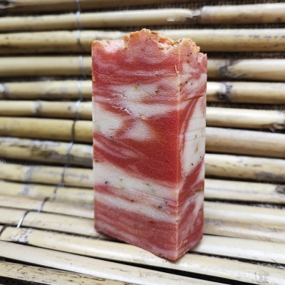 Sabonete marmoreado vermelho e branco sobre bambu