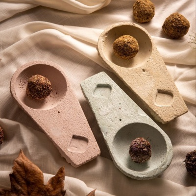 Três incensários pastel com bolas de incenso em tecido bege claro e folhas secas