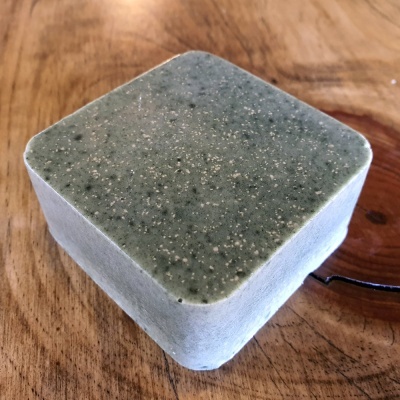 Objeto quadrado granulado cinzento sobre madeira clara