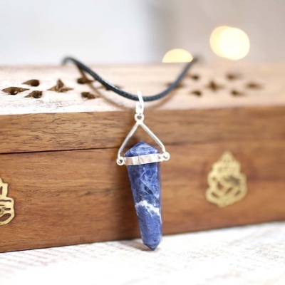 Colar com pendente em pedra azul e branca facetada com suporte em metal prateado e cordão preto