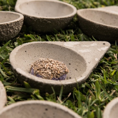Pequenas tigelas de cimento cinzento com diferentes texturas sobre relva